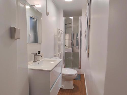 une salle de bain blanche avec des toilettes et un lavabo dans l'établissement Appart'HomeCity - Rouen Marne 1850, à Rouen