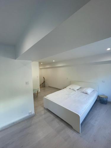 une chambre blanche avec un lit blanc dans une pièce dans l'établissement Loft Fourvière, à Lyon