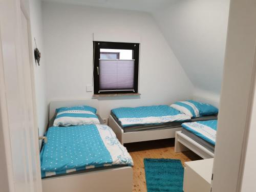 een kamer met 3 bedden en een spiegel bij Ferienhaus Lichtenberg in Herleshausen