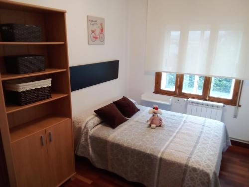 ein Teddybär sitzt auf einem Bett in einem Schlafzimmer in der Unterkunft Apartamento Teresa en Vilanova de Arousa in Pontevedra