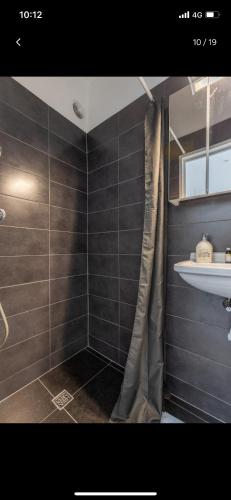 łazienka z zasłoną prysznicową i umywalką w obiekcie Charmante studio op toplocatie aan Meir. w Antwerpii