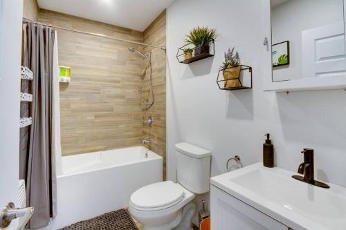 a bathroom with a toilet and a tub and a sink at La Maison Grenier La Résidence Beauport in Quebec City