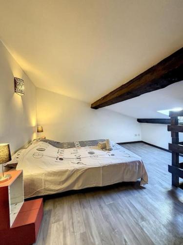 une chambre avec un grand lit et un parquet dans l'établissement Casa Bastide - Carcassonne Centre, à Carcassonne