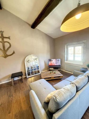 un salon avec un canapé et une télévision dans l'établissement Casa Bastide - Carcassonne Centre, à Carcassonne