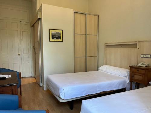 a hotel room with two beds and a telephone at Gran Hotel Balneario de Liérganes in Liérganes