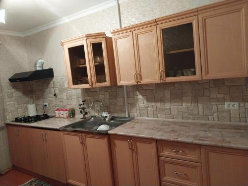 a kitchen with wooden cabinets and a sink at GALA Guesthouse in Alaverdi