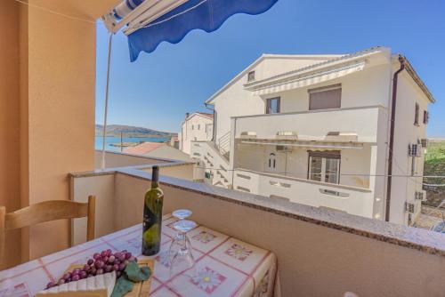 a table with a bottle of wine and grapes on a balcony at Veli Zal in Zubovići