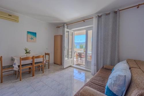 a living room with a couch and a dining room with a table at Veli Zal in Zubovići