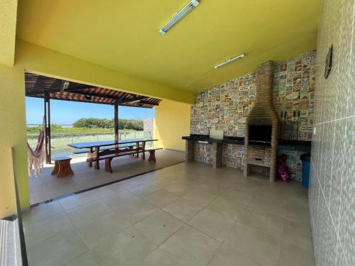 een woonkamer met een tafel en een open haard bij Casa beira rio-mar in Barra de São Miguel