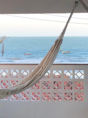 a hammock on a balcony overlooking the ocean at CASA BRANCA NA PRAIA in Icapuí