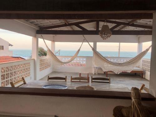 een veranda met hangmatten en uitzicht op de oceaan bij CASA BRANCA NA PRAIA in Icapuí