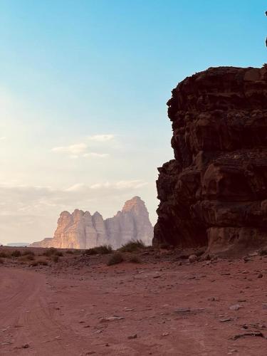 a dirt road in the desert with mountains in the background at Lulua luxury camp in Wadi Rum