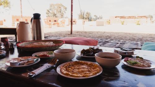 a table with plates of food on top of it at Stamps Siwa Oasis in Siwa