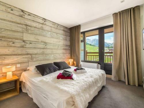 - une chambre avec un lit et un mur en bois dans l'établissement Appartement luxueux 75m², 6 pers, centre Val d'Isère, front de neige, terrasse sud - FR-1-567-22, à Val dʼIsère