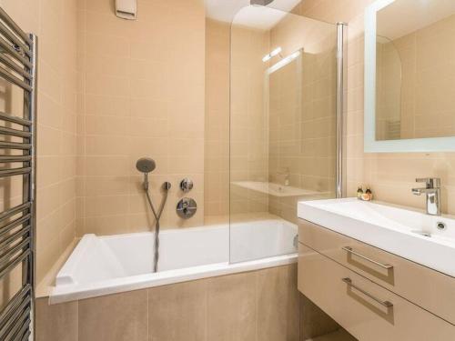 une salle de bain avec une baignoire et un lavabo dans l'établissement Appartement luxueux 75m², 6 pers, centre Val d'Isère, front de neige, terrasse sud - FR-1-567-22, à Val dʼIsère