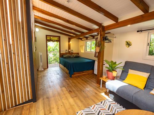 a living room with a couch and a table at Kalinao - Bungalow chic en nature in Les Abymes