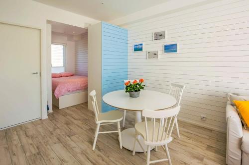 Cette petite chambre comprend une table, des chaises et un lit. dans l'établissement Surf and Turf Apartment in Hanko, à Hanko
