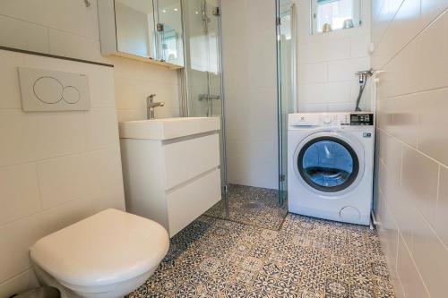 a bathroom with a washing machine and a washer at Surf and Turf Apartment in Hanko in Hanko