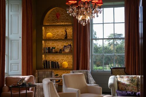 a living room with chairs and a chandelier at Bishopstrow Hotel and Spa - Small Luxury Hotels of the World in Warminster
