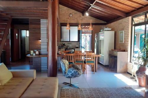 a living room with a couch and a dining room at Refúgio paradisíaco em frente a Serra da Bocaina ! in São José do Barreiro