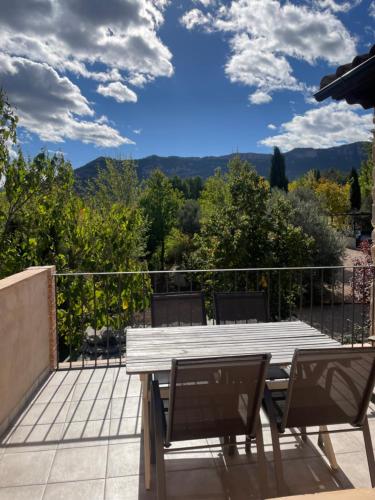 a wooden table and chairs on a patio with a view at Maset del Riu in Valderrobres