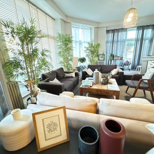 a large living room with couches and a table at Cit'Hotel Les Alizes in Dinard
