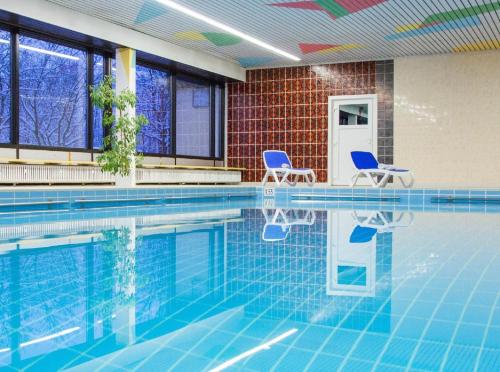 a swimming pool with two chairs and a table andermottermott at Ferienwohnungen Bayerwaldblick im Ferienpark Geyersberg in Freyung