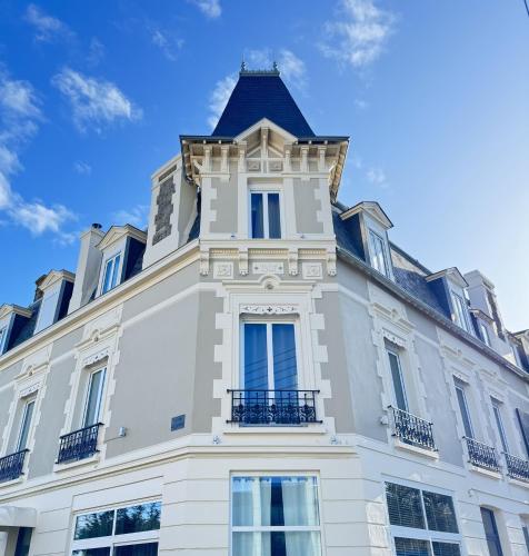 a building with a tower on top of it at Cit'Hotel Les Alizes in Dinard
