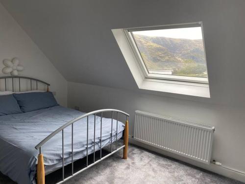 a bedroom with a bed and a window at Cois Locha in Glenbeigh