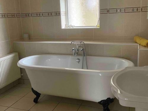 a white bath tub in a bathroom with a sink at Cois Locha in Glenbeigh