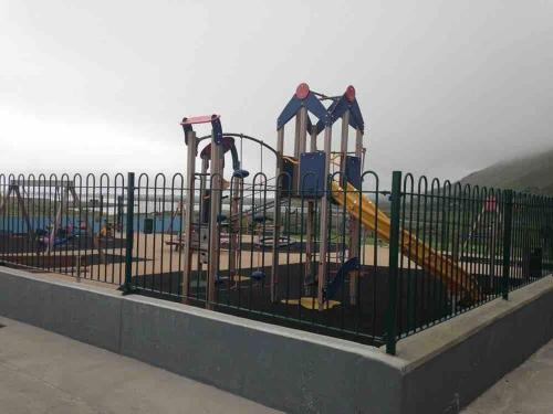 a park with a playground behind a fence at Cois Locha in Glenbeigh