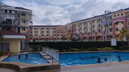 a group of people in a swimming pool with buildings at Minimalist 1 Bedroom Condo at Arezzo Place Davao in Davao City