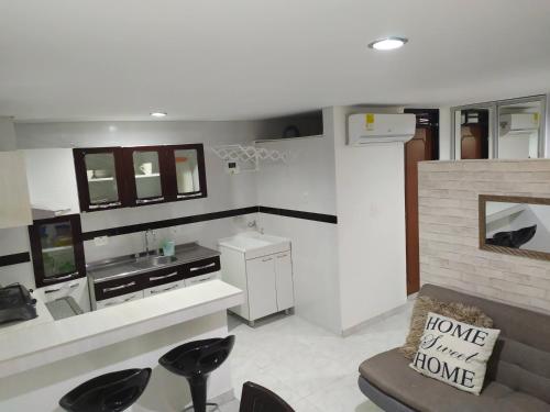 a kitchen with a counter and chairs in a room at Cómodo apartaestudio en Cali para corta o larga estadía in Cali