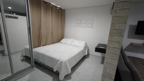 a small bedroom with a bed and a mirror at Cómodo apartaestudio en Cali para corta o larga estadía in Cali