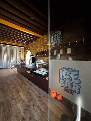 a room with a kitchen with a table and a counter at HI Serra da Estrela - Pousada de Juventude in Penhas da Saúde