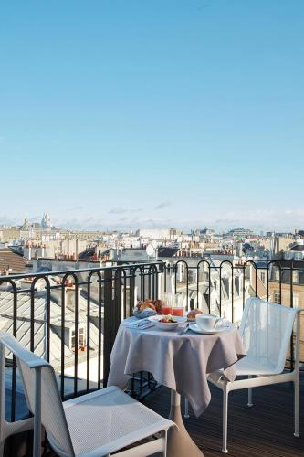 a table and chairs on a balcony with a view at Villa-des-Prés in Paris