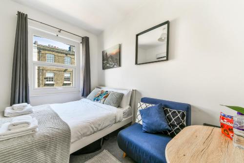una camera con letto, tavolo e finestra di Chapel Market Apartment a Londra