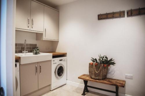 a kitchen with a sink and a washing machine at Glebe House in Barford Saint Martin