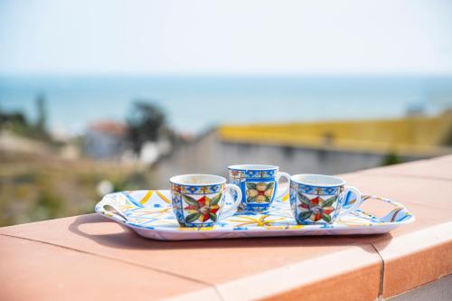 three coffee cups on a plate on a table at apartament scala dei turchi e Piscina in Realmonte