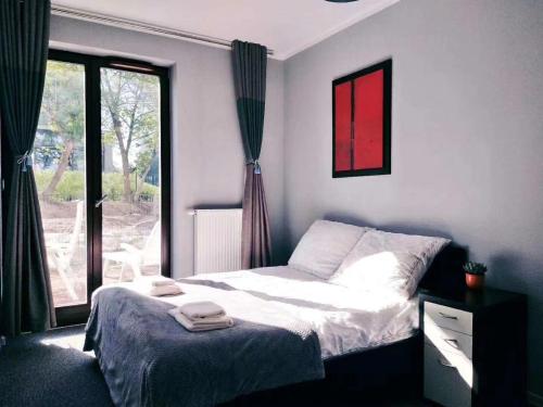 1 dormitorio con cama y ventana grande en Near airport cybernetyki Inn, en Varsovia