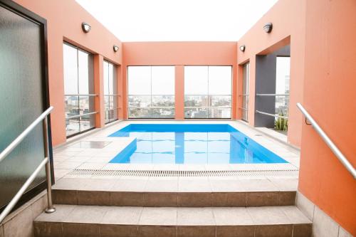 an indoor swimming pool in a building with windows at Los Tallanes Hotel & Suites in Lima