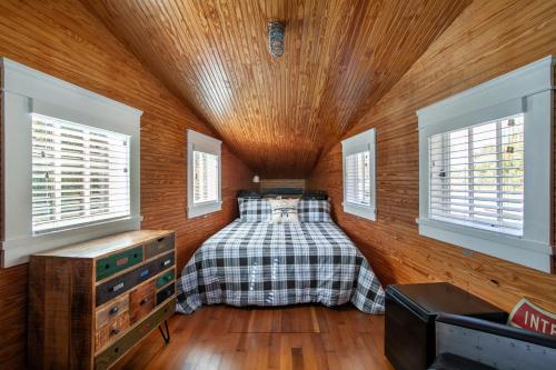 a bedroom with a bed in a wooden room with windows at Airplane Filling Station -Unique Stay in Knoxville in Knoxville