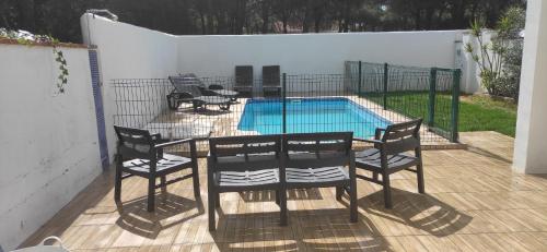 a table and chairs in front of a swimming pool at Villa Conil in Conil de la Frontera
