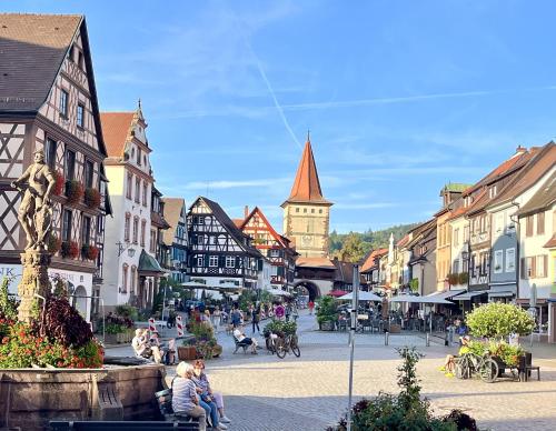 a group of people sitting on benches in a city street at Coucou - Nest im Schwarzwald in Gengenbach
