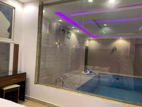 a bathroom with a large tub with purple lighting at شاليه أوركيد محايل عسير in Ar Raysh
