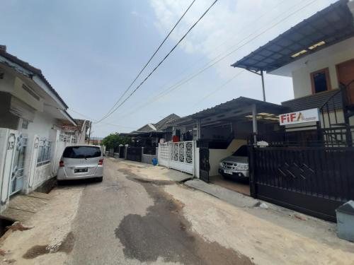 a car parked on a street next to a house at Fifa Homestay & Villa 2BR in Tanjungkarang