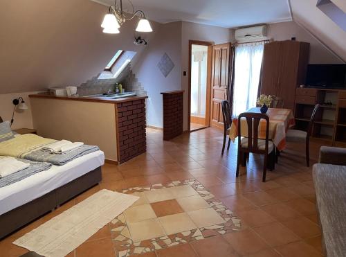 a bedroom with a bed and a table and chairs at Rozmann Family Panzió & Apartmanhaz in Sárvár