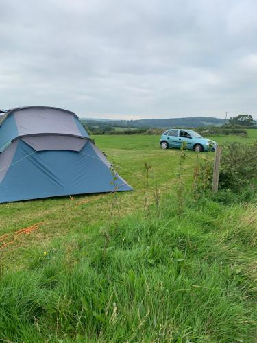 a blue tent and a car in a field at Poplars Farm Adults only Touring Site empty pitches in Ireton Wood