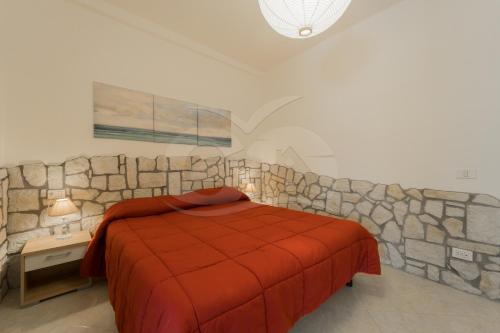 een slaapkamer met een bed en een stenen muur bij Azzurro Mare a Seccheto - Goelba in Seccheto