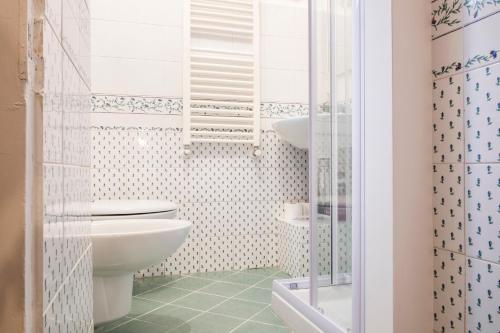 ein weißes Bad mit einem WC und einer Dusche in der Unterkunft Fontebella 46 in Assisi